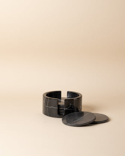 Black marble coaster set on a beige background