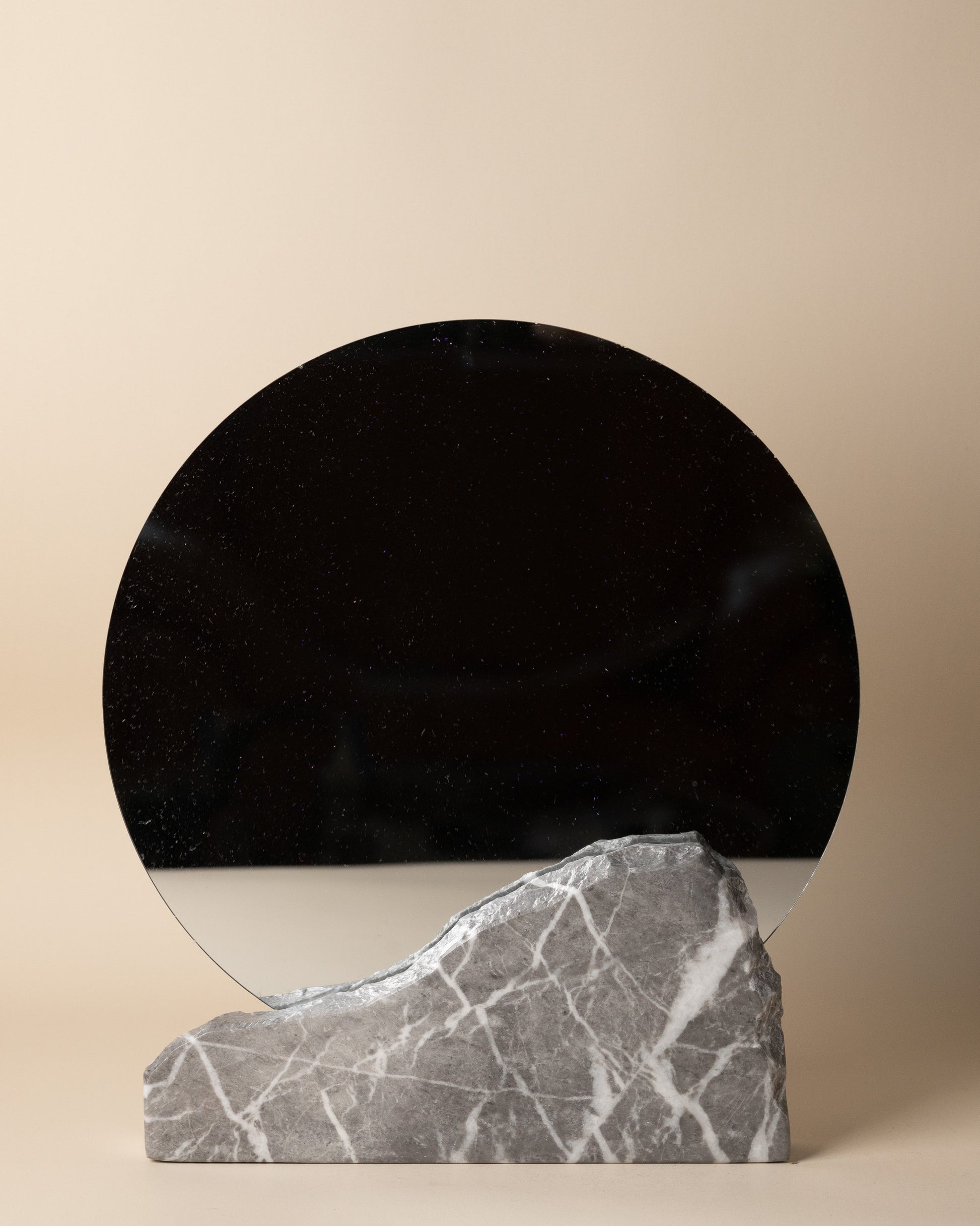 Luxuriöser Tischspiegel aus grauem Marmor von Marmonix mit eingesetztem runden Spiegel, der das elegante Zusammenspiel von Glas und skulpturalem Naturstein auf dem Schminktisch zeigt.