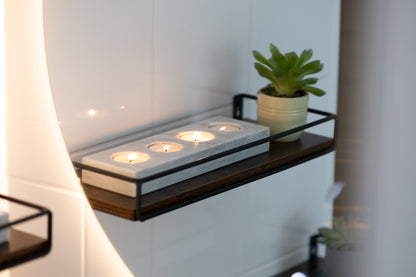 Das lange weiße Marmor-Teelichter-Centerpiece von Marmonix, stimmungsvoll erleuchtet auf einer festlichen Sideboard im Badezimmer.