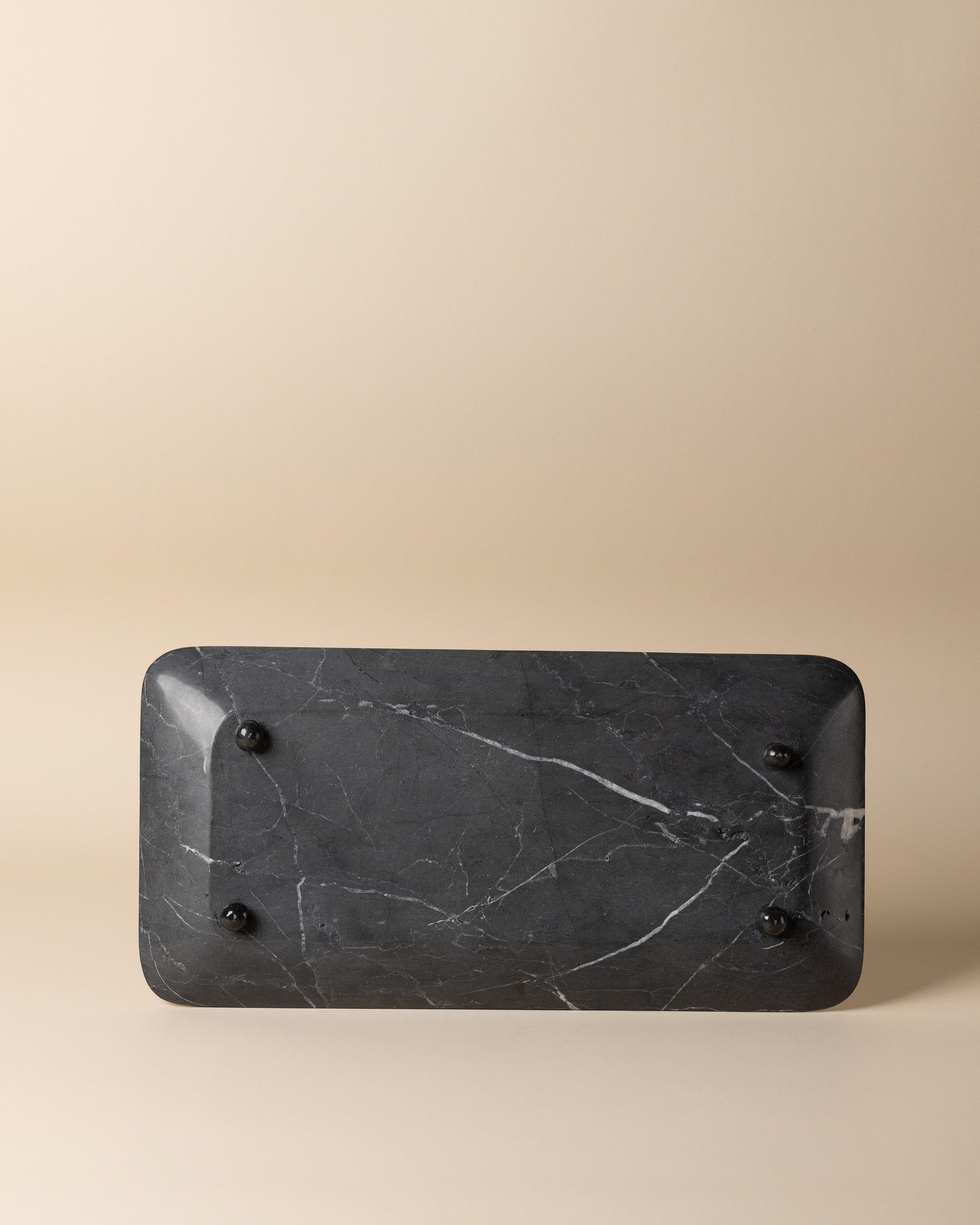 Black marble tray on a beige background
